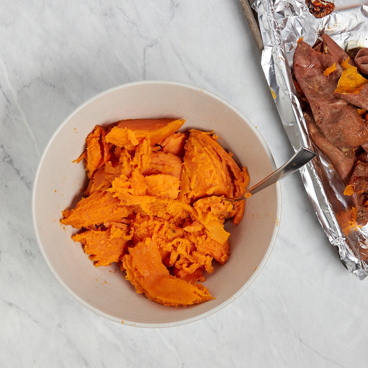 baked sweet potato in a bowl with the skin removed.