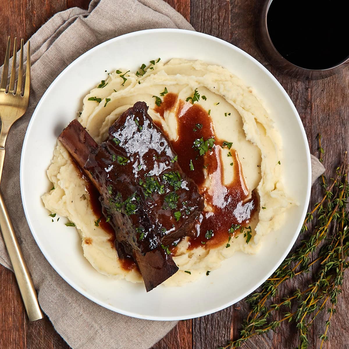 braised short rib with mashed potatoes and gravy in a white bowl.