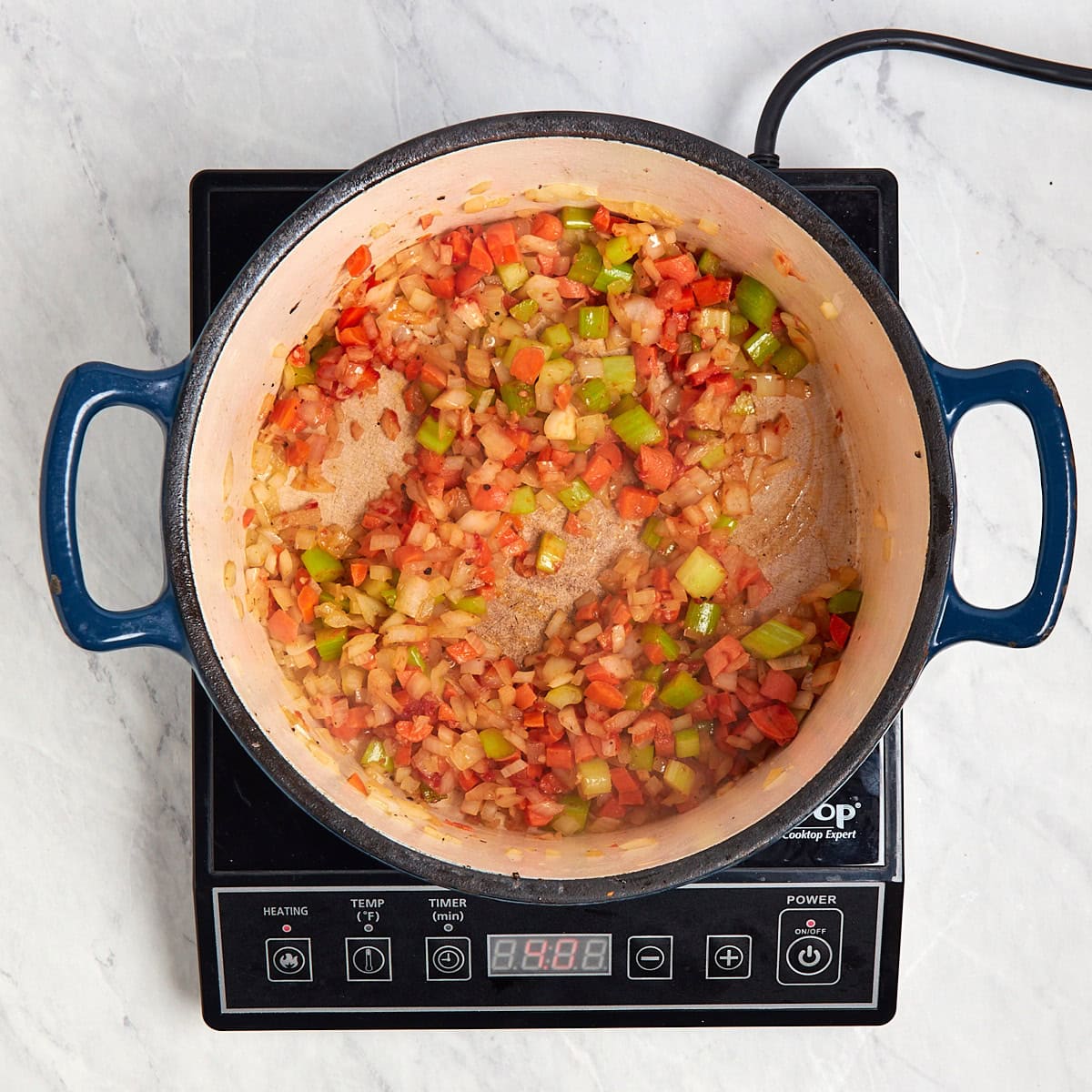 tomato paste cooking with the mirepoix in a Dutch oven.