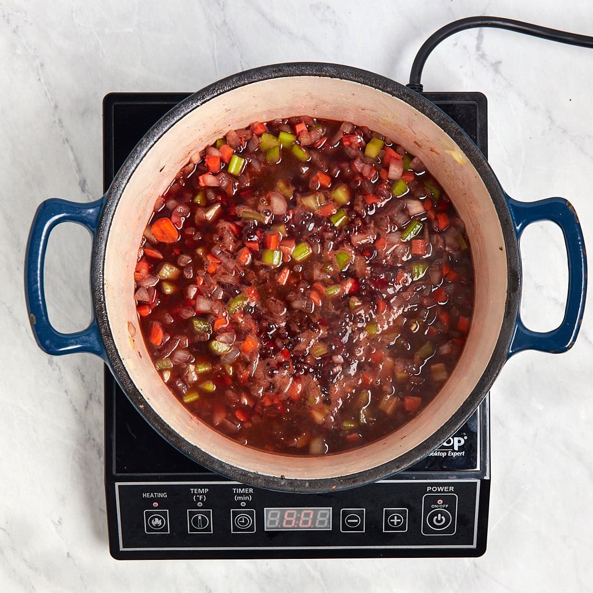 red wine simmering in the Dutch oven with the aromatics.