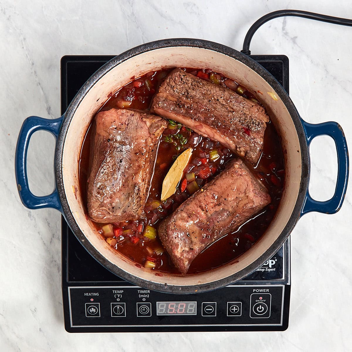 browned short ribs in the Dutch oven with the red wine, broth, herbs, and mirepoix.
