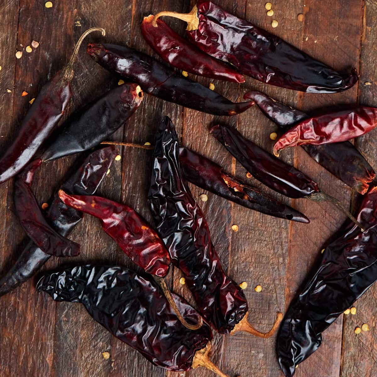 dried chiles on a wood background.