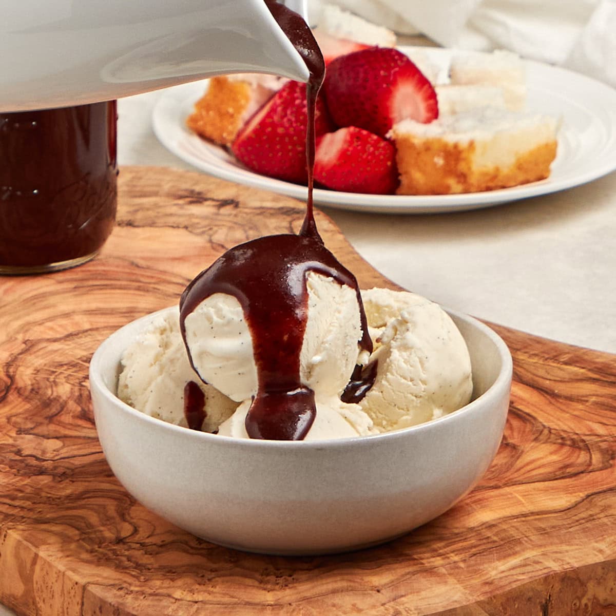 chocolate sauce drizzled on a bowl of vanilla ice cream.