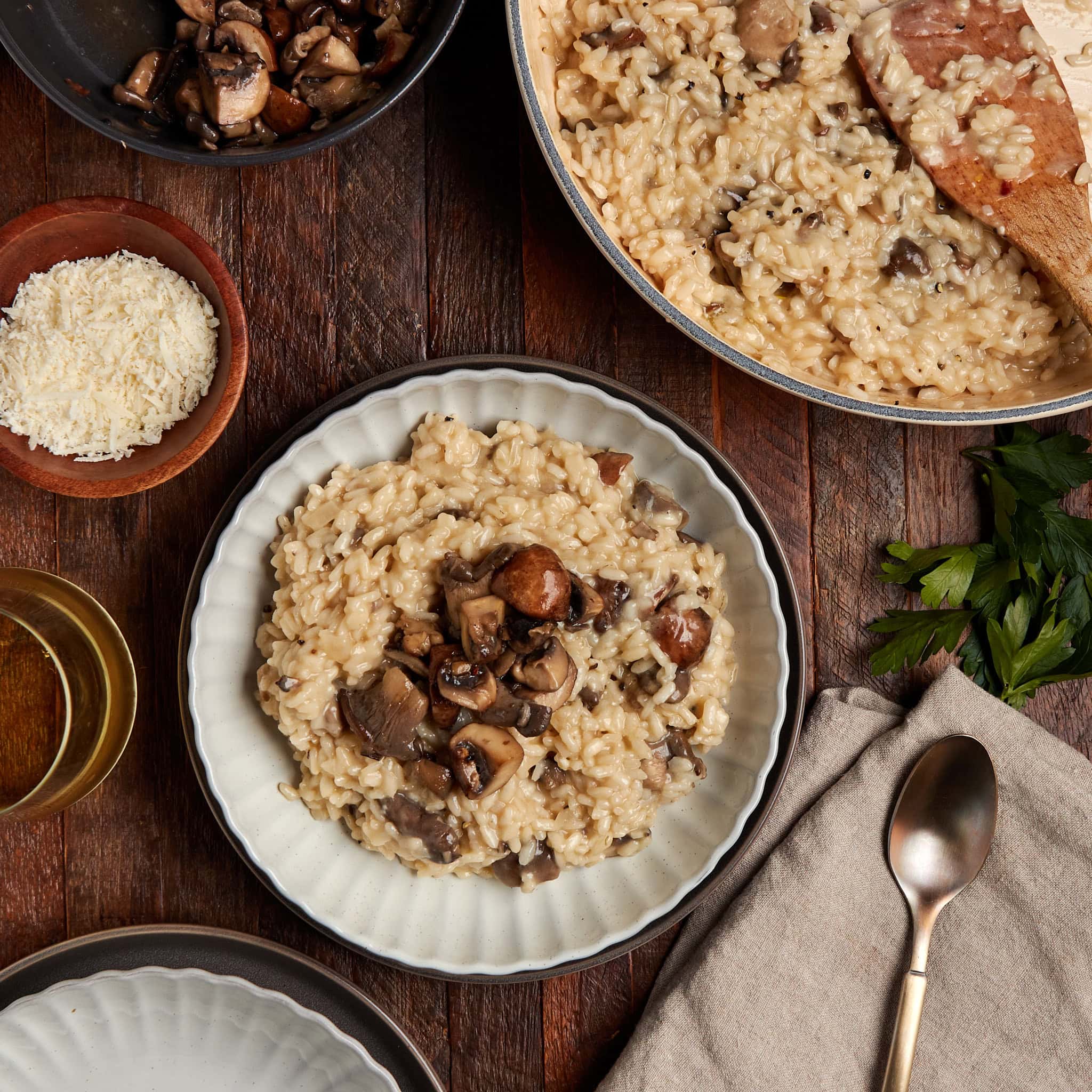 mushroom truffle risotto in a white bowl with a side of extra cheese.