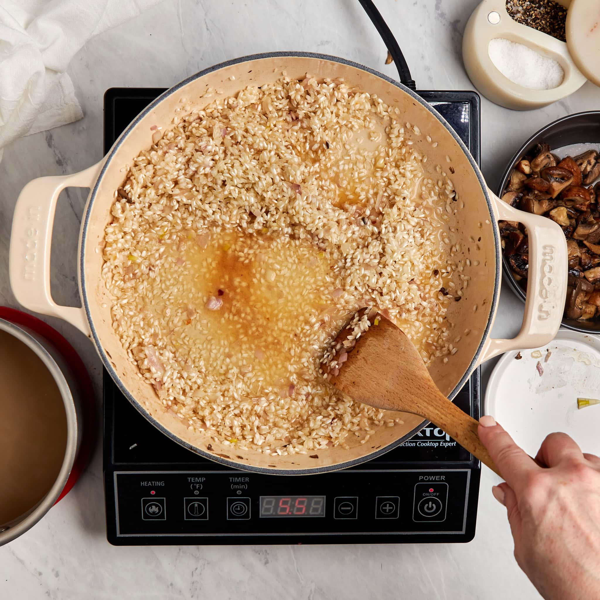 arborio rice and white wine in a braiser on a portable induction cooktop.