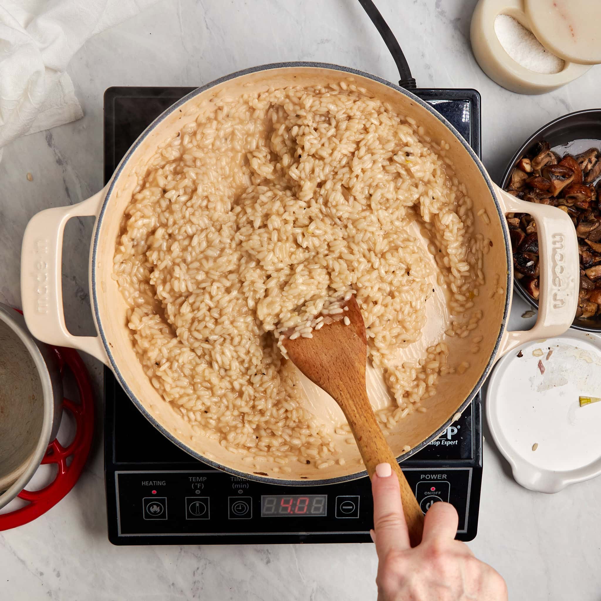 risotto in a braiser being stirred.