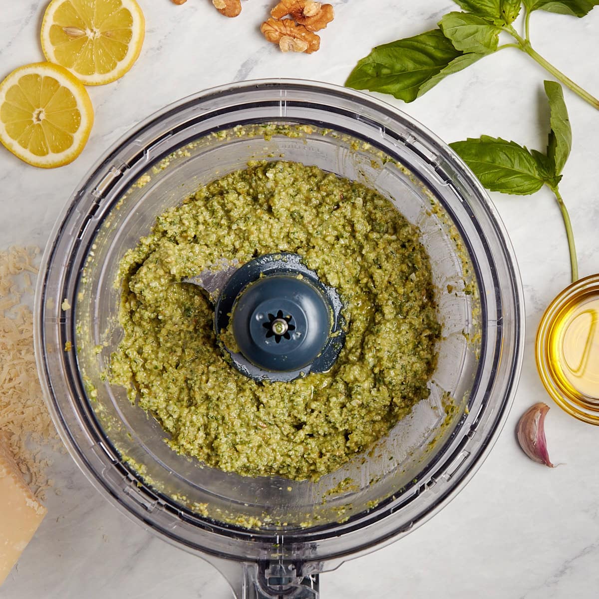 basil walnut pesto in food processor after having olive oil added.
