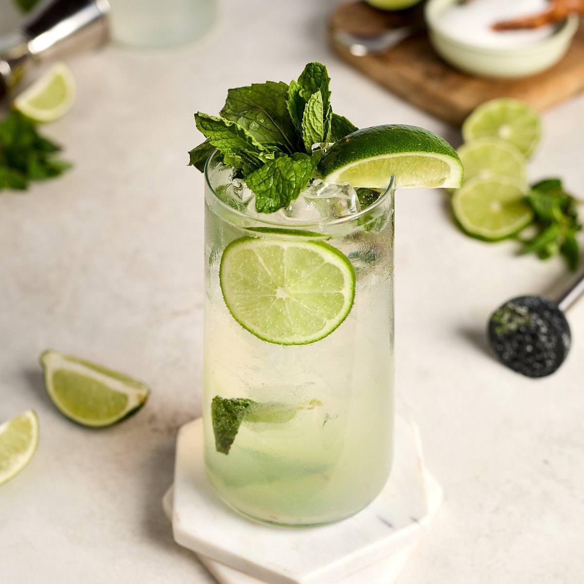 classic mojito in a glass garnished with mint and limes.