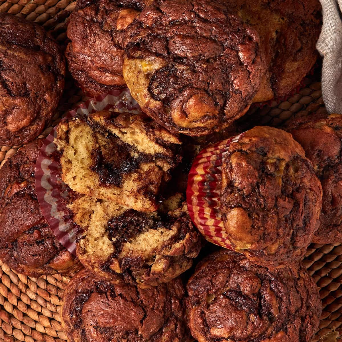 banana nutella muffins stacked on a placemat.