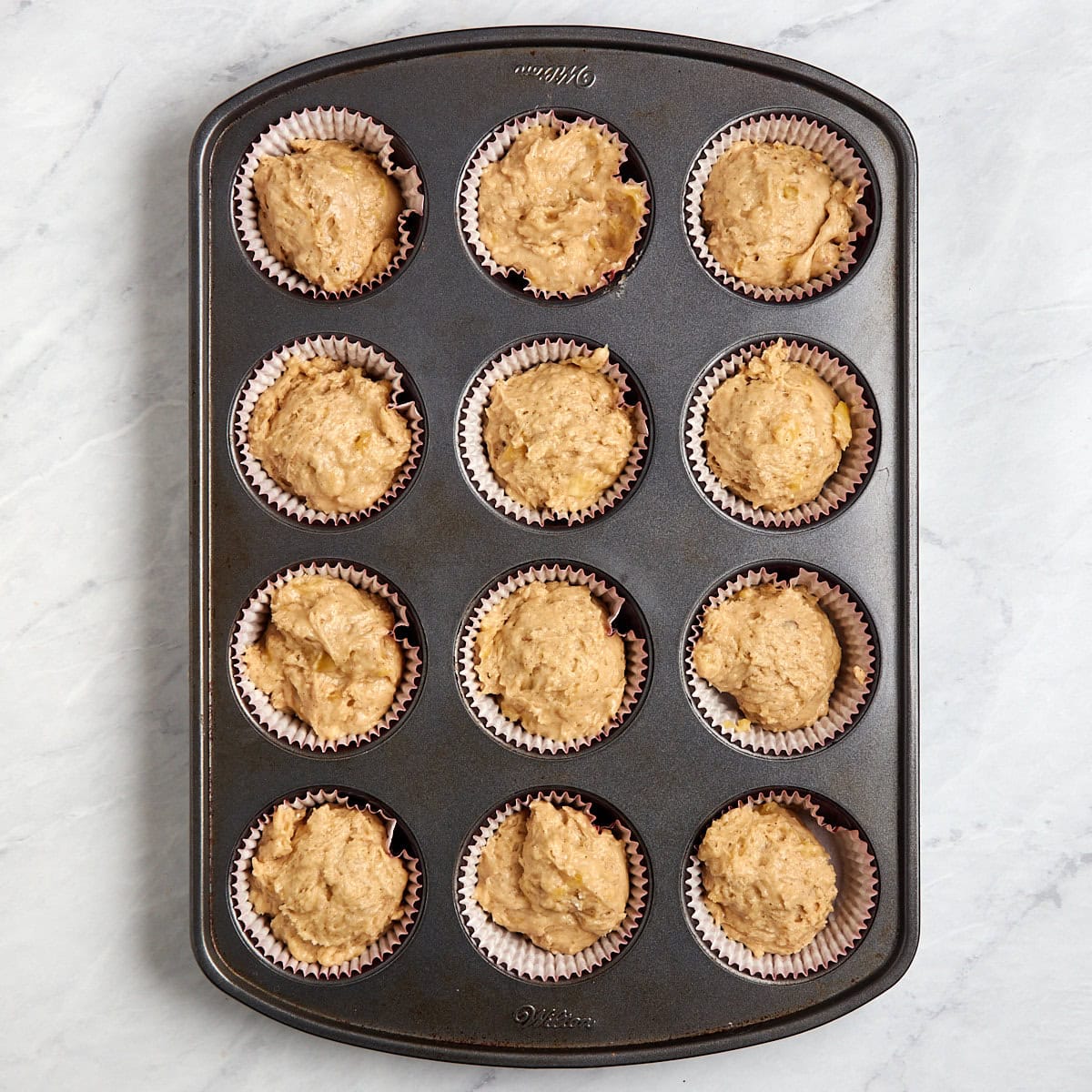 unbaked banana mix in a muffin tin.