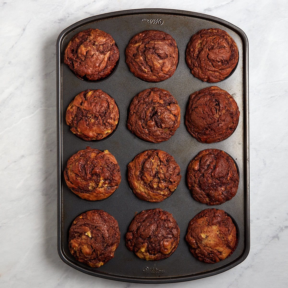 baked banana nutella muffins in a muffin tin.