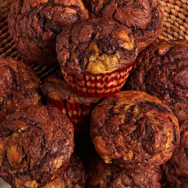 banana nutella muffins stacked on a placemat.