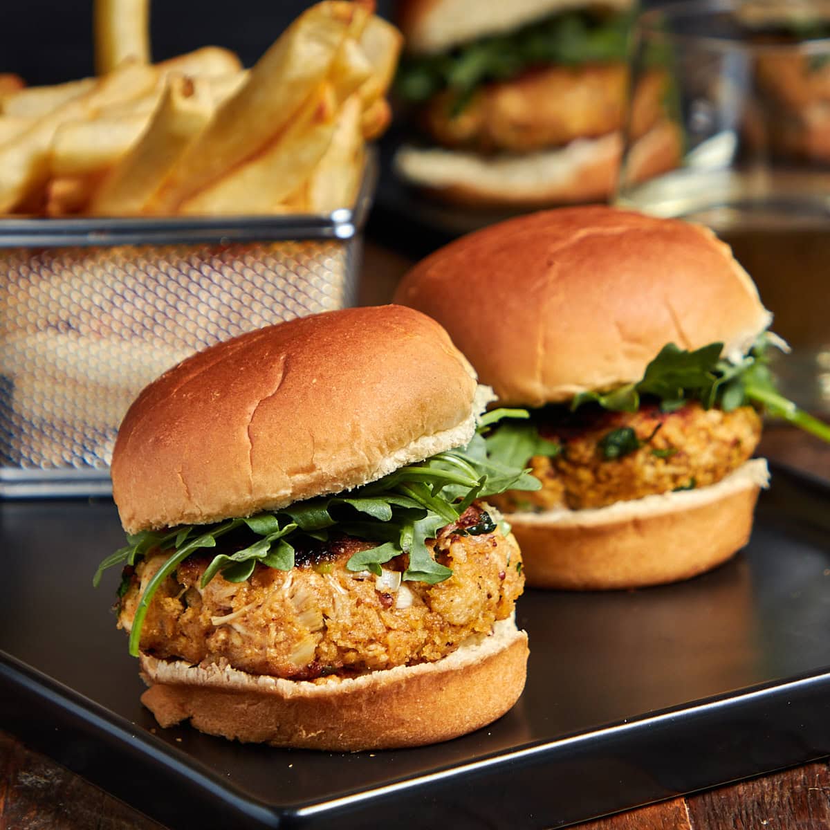 two sliders on a black plate with a side of fries.
