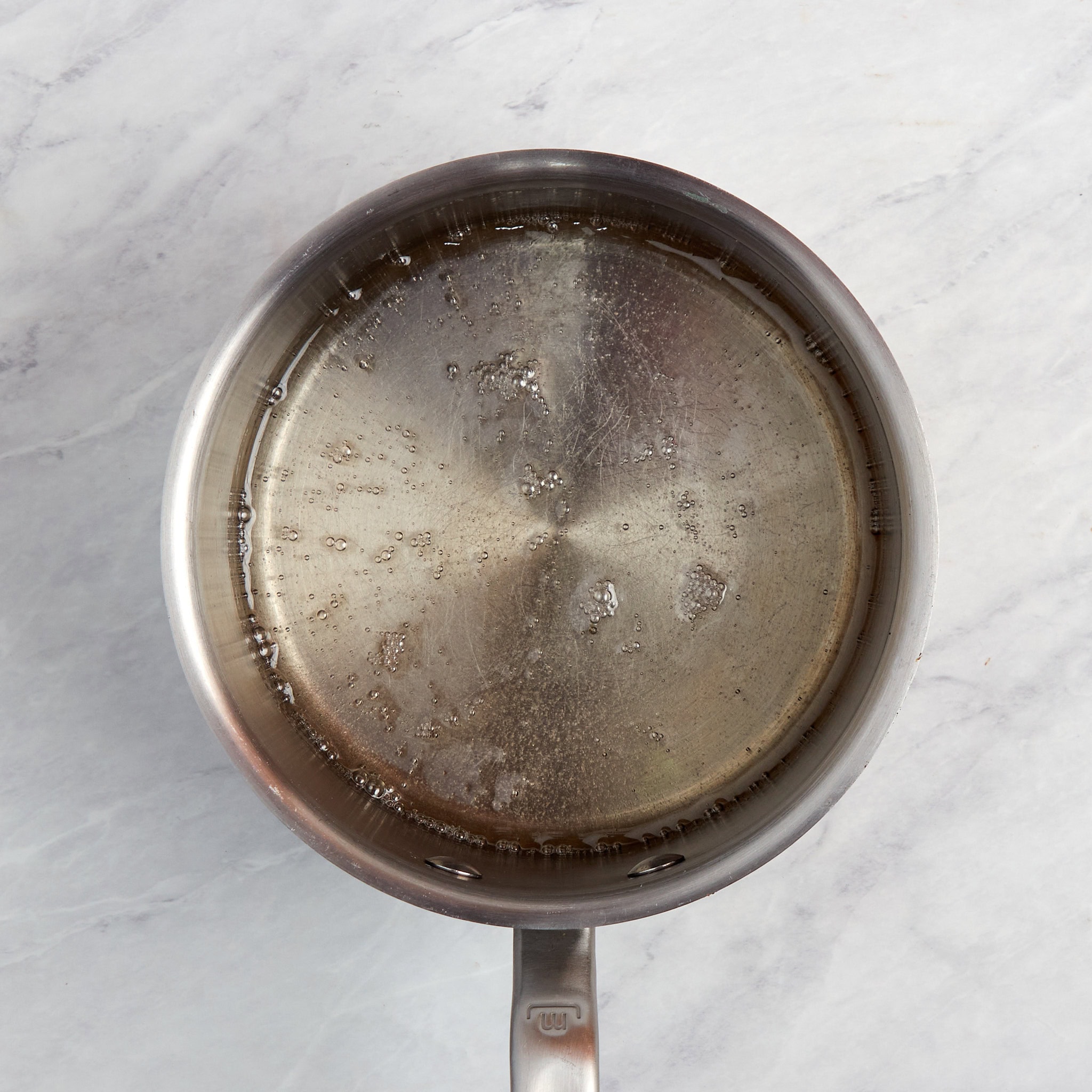 sugar and water boiling in a pan.