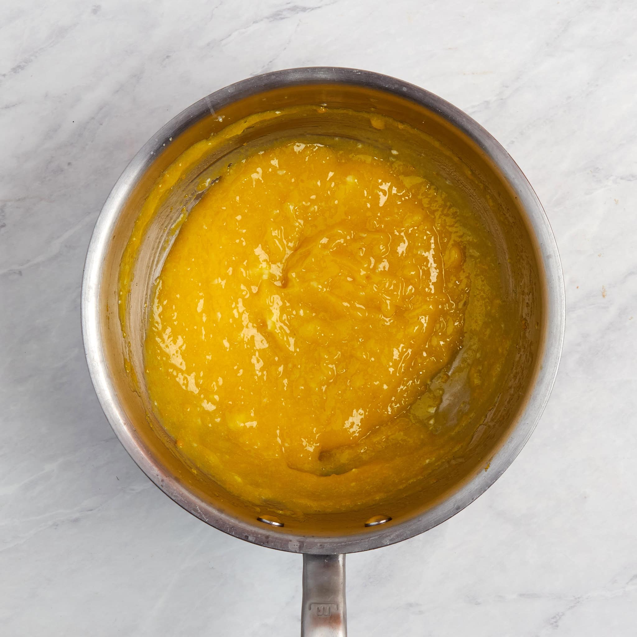 lemon curd thickened in a saucepan.