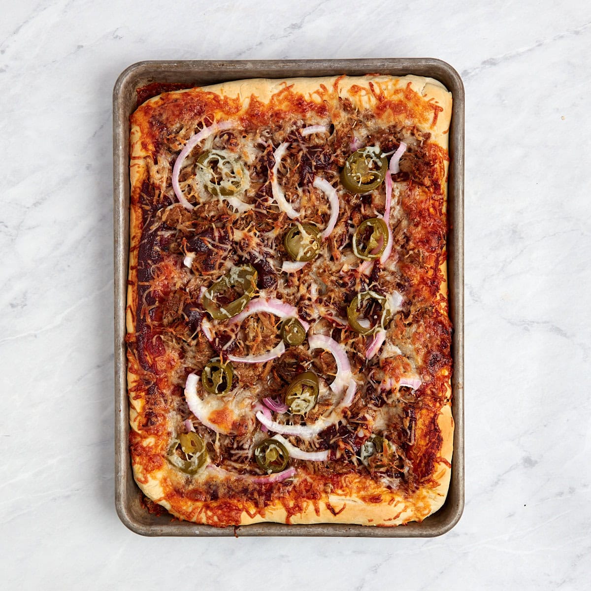 baked pulled pork pizza in a sheet pan.