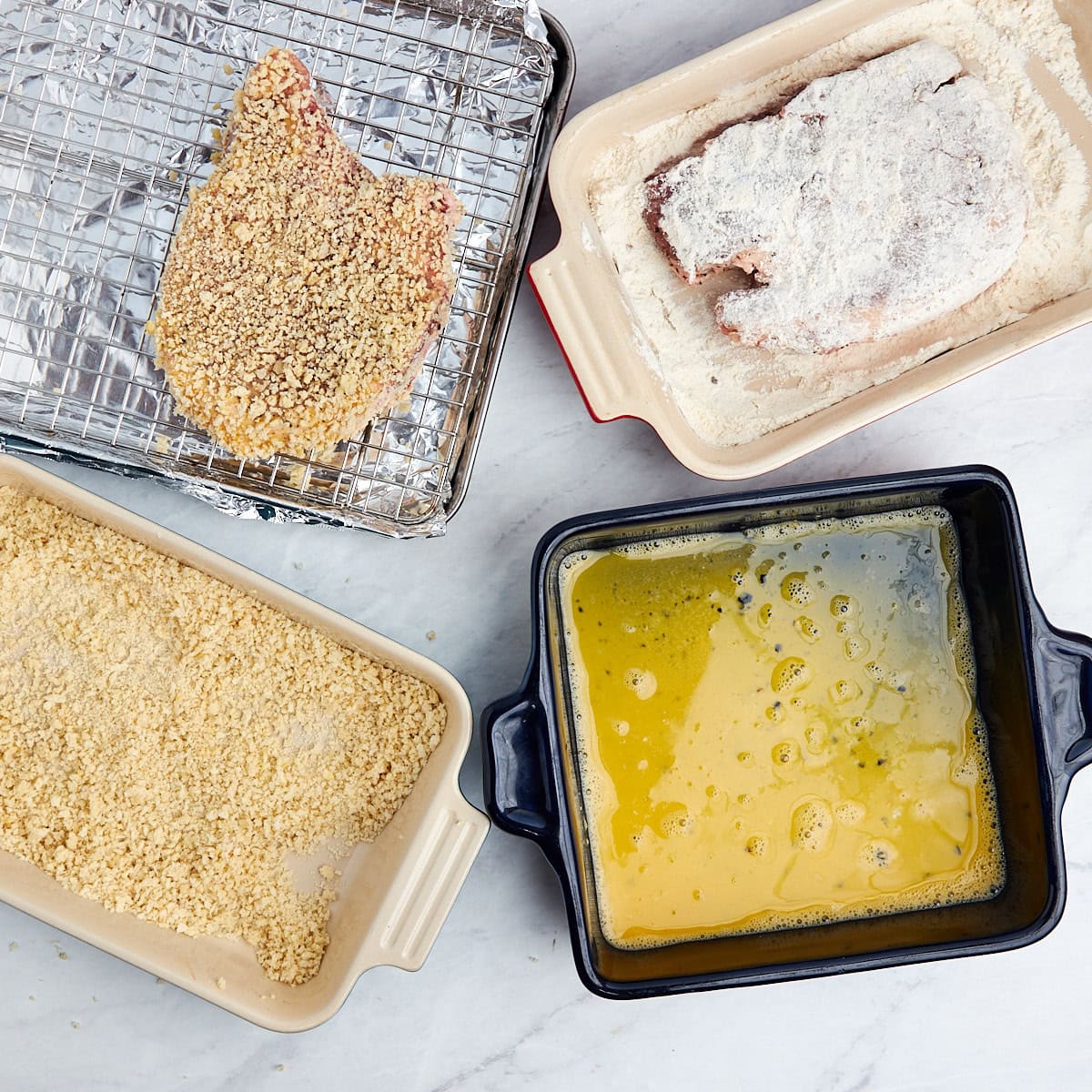 pork chop being coated in flour.