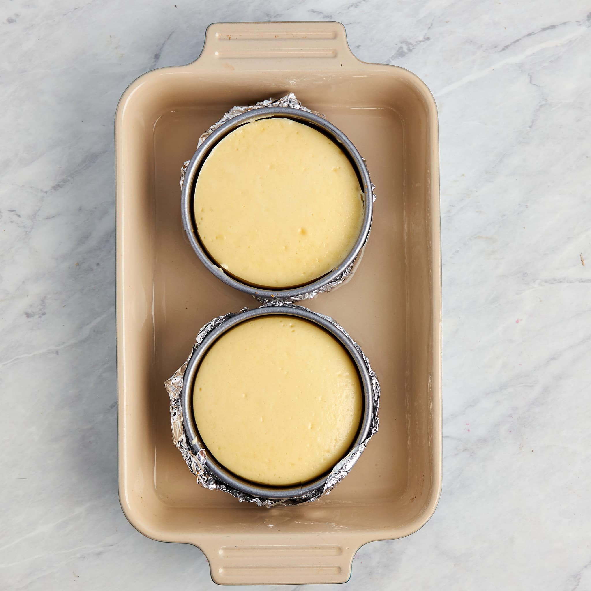 two individual cheesecakes baked in a water bath.