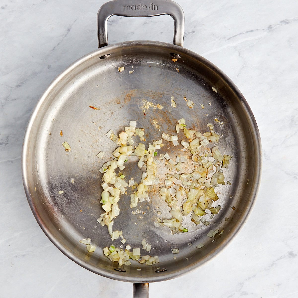 shallots and garlic cooking in a large skillet with butter.