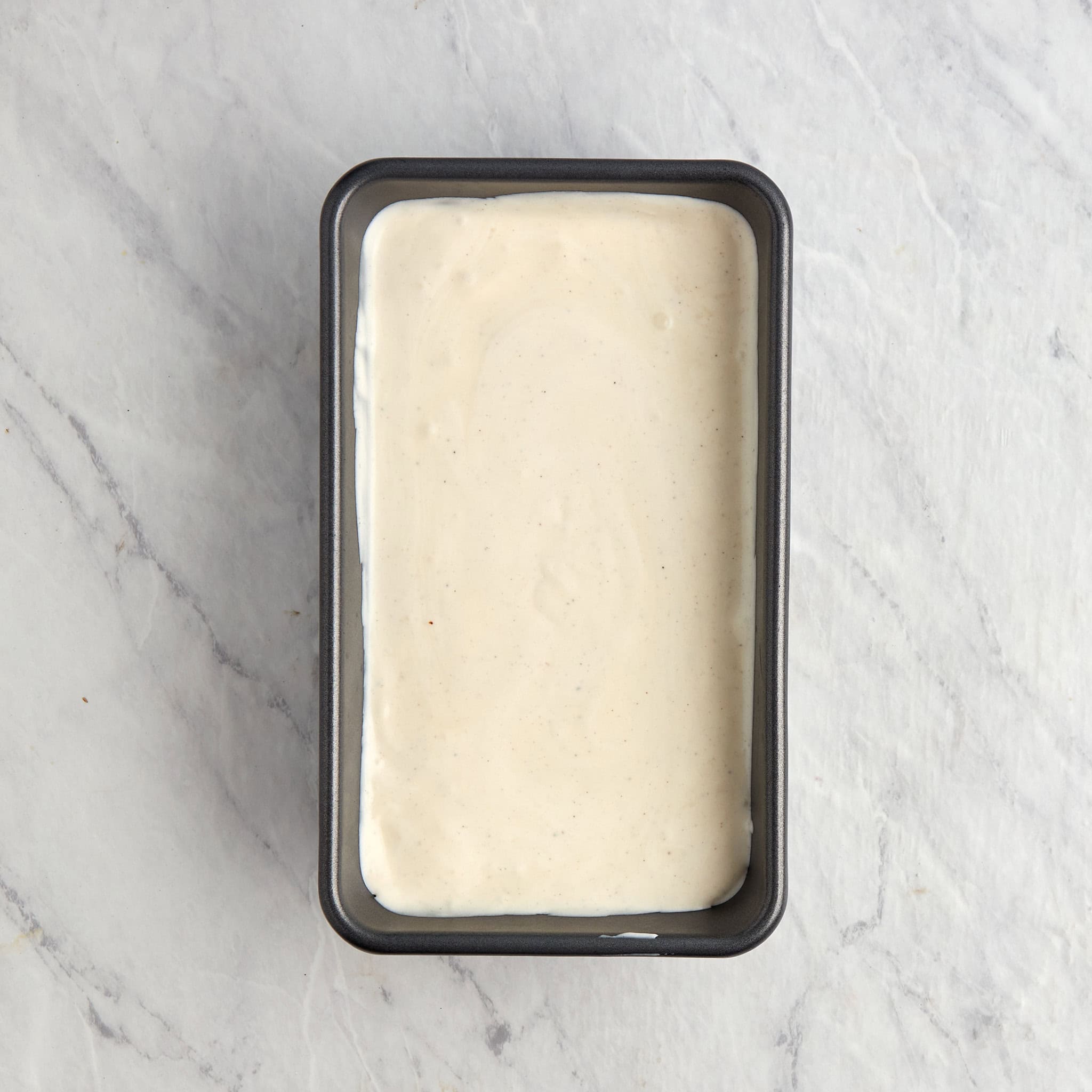 unfrozen vanilla ice cream in a loaf pan.