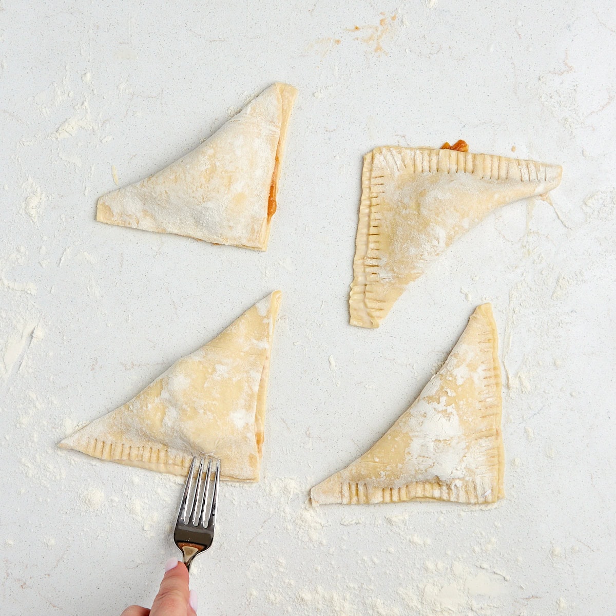 turnovers being sealed with a fork.