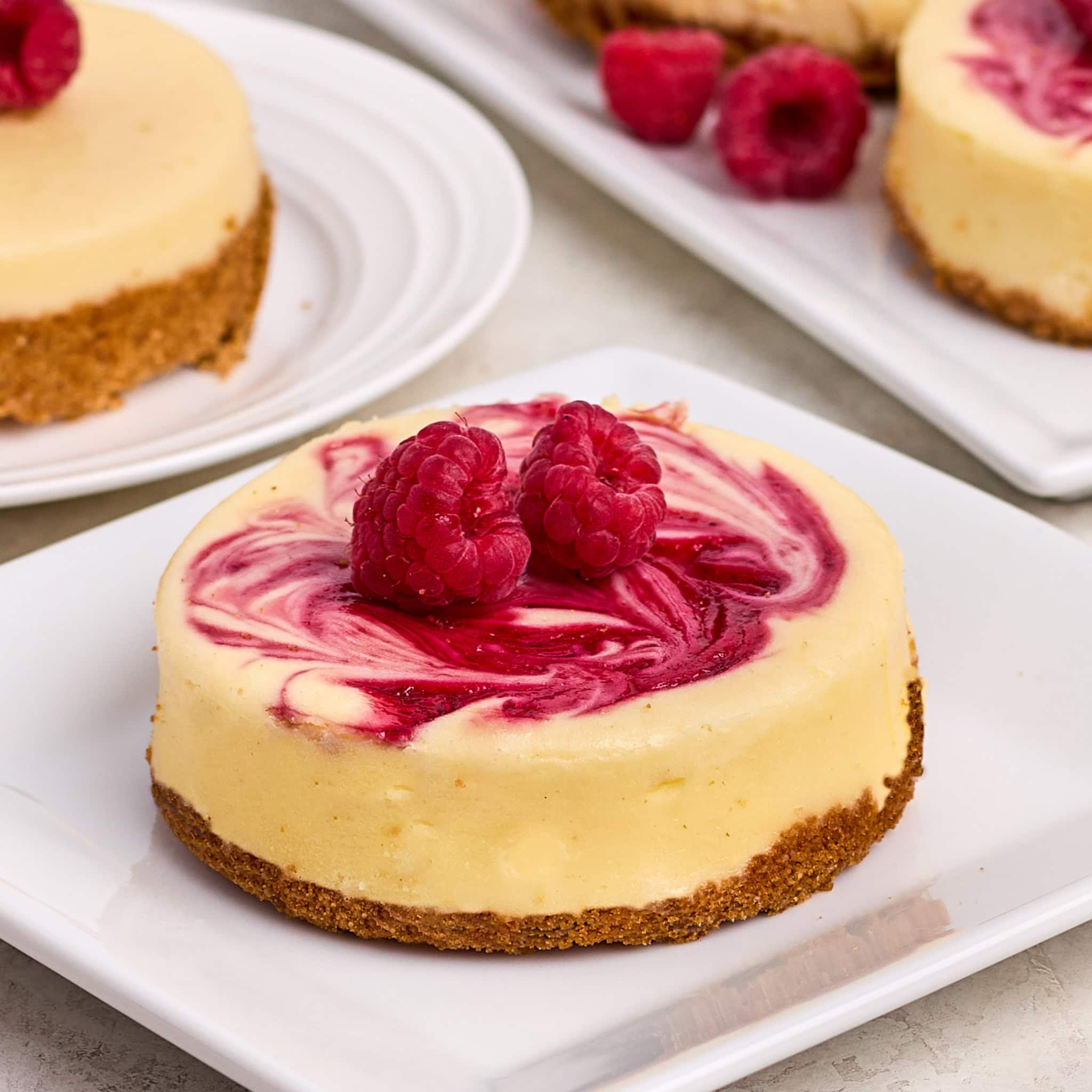 raspberry swirl cheesecake on a white plate.