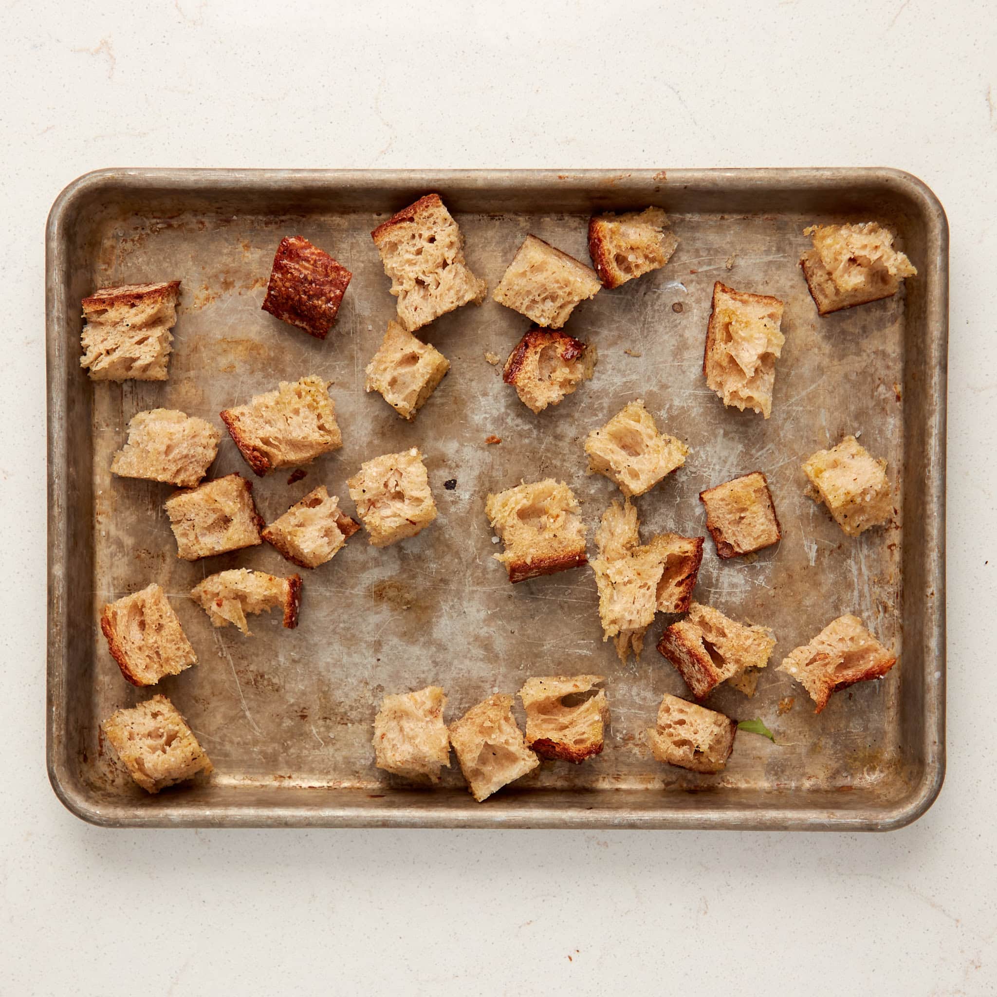 cubed bread on a baking sheet.
