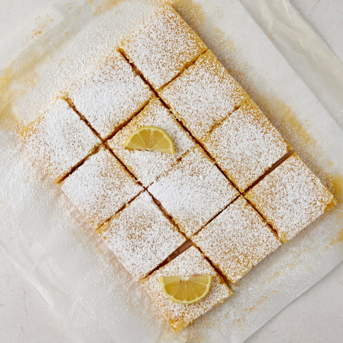 lemon bars cut into 12 individual pieces and sprinkled with powdered sugar.
