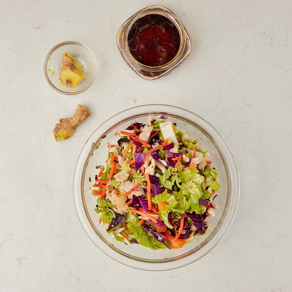 mandarin orange salad in a clear bowl tossed with the dressing.
