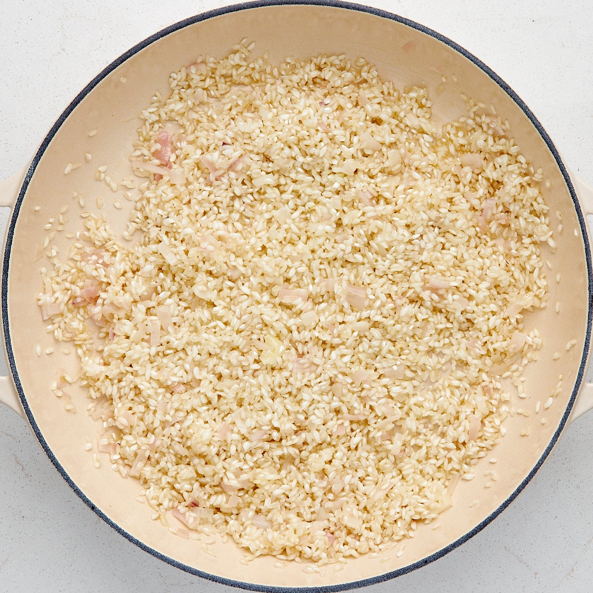 arborio rice sautรฉing in shallots and oil.